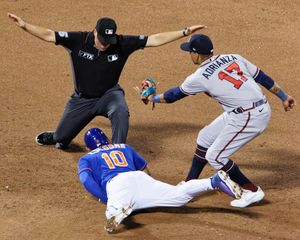 베이스 심판 스튜 셰어워터가 에두아르도 에스코바르의 세이프를 선언한다.