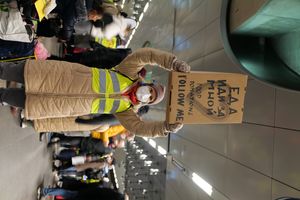  베를린 기차역에서 난민 안내 표지판을 들고 있는 자원 봉사자