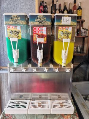 이탈리아의 슬러시 기계, 민트향, 콜라향, 레몬향 음료 혼합물을 담고 있다.