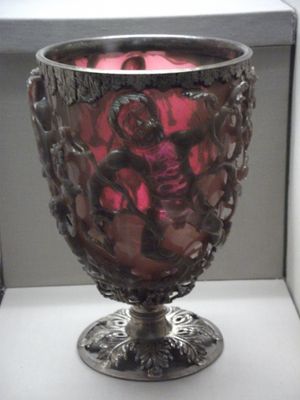 뒤에서 조명을 비춘 리커거스 컵(Lycurgus Cup), 이색성(dichroic) (색상 변화) 케이지 컵으로 현대식 받침대와 테두리가 있다.