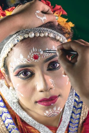 메이크업 아티스트가 오디시 춤 공연 전에 작업하는 모습