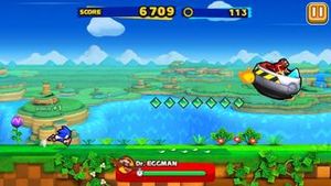 소닉, 플레이어 캐릭터가 닥터 에그맨의 방해를 받으며 앞으로 달리고 있다.