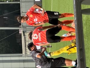 다카야마 가즈마(왼쪽)가 동료 선수인 쿠리야마 나오키와 함께 부상당한 브루나이 DPMM 선수를 돕고 있다.