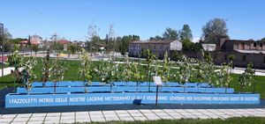 전 에테르니트 공장 부지에 있는 석면 피해자 기념비. "우리 눈물에 젖은 손수건이 날개를 달고 멀리 날아가 정의의 깊은 뿌리를 내릴 것입니다"라고 적혀 있다.