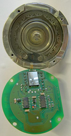 13 트랙의 그레이 코드 절대 회전형 인코더. 하우징, 인터럽터 디스크 및 광원은 상단에 있고, 감지 요소와 지지 구성 요소는 하단에 있다.