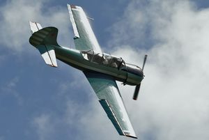 Yak-52가 곡예 비행 기동 중 보조 날개를 사용하여 반시계 방향으로 회전하는 모습