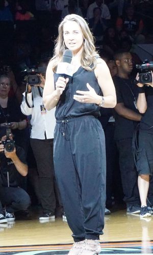 Becky Hammon, Holding a microphone in a spotlight, speaking to the audience during her induction into the Ring of Honor