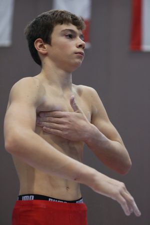 체조 선수가 활석을 사용하여 큰가슴근을 활성화하고 보호하는 모습