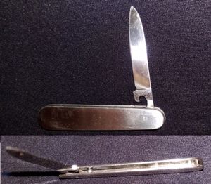 중력 잠금 볼 베어링 주머니칼. 홈 안팎으로 떨어지는 구슬로 잠긴다. 해제하려면 칼날이 위로 향하게 하고 눌러야 하며, 잠그려면 칼날이 아래로 향하게 하고 눌러야 한다.