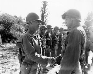 제1기병사단 사령관 호바트 R. 게이 소장이 1950년 8월 25일, 한국에서의 공로를 인정하여 레이먼드 A. 웰란 중위에게 은성 훈장을 수여한 후 축하하는 모습