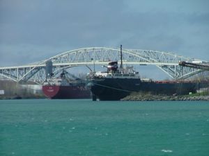블루 워터 브리지(Blue Water Bridge)에 의해 틀이 잡힌 두 척의 호수 화물선이 사니아 항구에서 화물을 싣고 있다.
