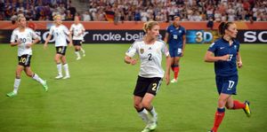 가에탄 티네는 파란색 유니폼을 입고 있으며, 비앙카 슈미트와 2011년 FIFA 여자 월드컵 프랑스-독일 경기에서 대결하고 있다.