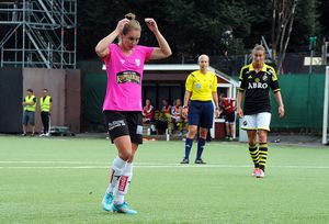 Woman in pink and black football kit