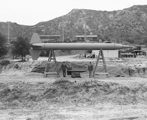 글래디언 M. 반스 소장(오른쪽)과 JPL 임시 국장 프랭크 말리나(왼쪽)가 1947년 5월에 발사된 39피트 코퍼럴 E 아래에 서 있다.