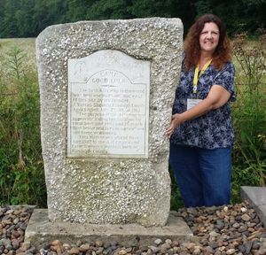 당시 웨스트버지니아 주 4-H 리더였던 데비 맥도날드가 새로 이전된 Camp Good Luck 표지석과 함께 포즈를 취하고 있다(2015년 7월 8일).