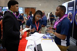 해군연구청 직원이 해군부 역사적으로 흑인 대학 및 대학교/소수 민족 기관(HBCU/MI) 프로그램 전시회 방문객과 유료 인턴십 기회에 대해 논의하고 있다.