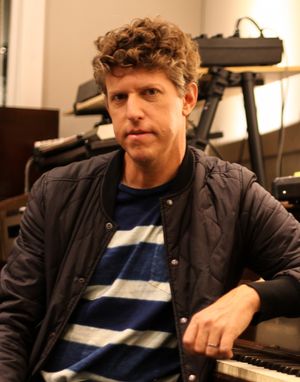 줄무늬 티셔츠와 재킷을 입은 Greg Kurstin
