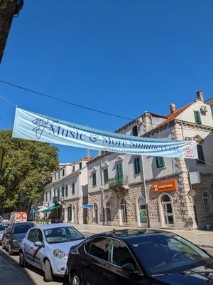 '뮤직 앤 모어 서머 페스티벌 2023'이 새겨진 배너가 트레비네의 '크랄자 페트라 1세 오슬로보디오차' 도로를 장식하고 있으며, 건물 2층 높이에 걸려 있다.