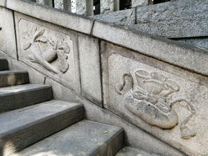 마츠치야마 혼류인 계단에 묘사된 환희천의 상징: 생식력과 부부의 결합을 상징하는 두 갈래 무와 부를 나타내는 돈주머니