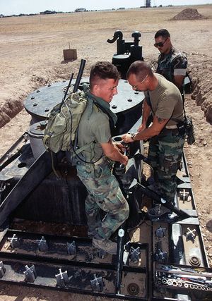 미 해병대가 육상 기반 어레스팅 기어의 제동 엔진을 작업하고 있다. 배경에 나일론 테이프 릴이 보인다.