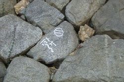 요시다 성의 돌담에 새겨진 각인(사진 중앙은 토사 가나 표기). 천하보통이었던 나고야 성의 석재 잔석을 요시다 성에 전용했음을 나타내는 것이라고 한다.