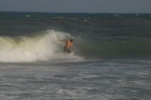 플로리다 해안에서 허리케인 노엘로 인한 파도 속에서 서핑하는 사람