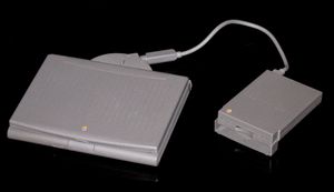 PowerBook Duo에 연결된 Duo MicroDock과 플로피 디스크 드라이브