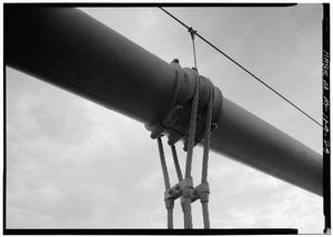 수직 행어 케이블의 클로즈업 뷰, 이는 "새들"이라고 불리는 것으로 더 큰 메인 케이블에 연결되어 있다.