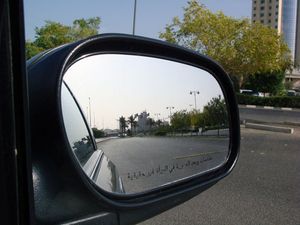아랍어로 된 "거울 속 물체는 실제보다 가깝게 보입니다" 경고문