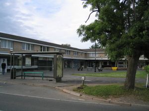 보행자 전용 구역에 있는 상점의 줄입니다. 앞쪽에는 버스 정류장과 나무가 있습니다.