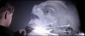 흑백 이미지와 컬러를 혼합하고, 등장인물이 후면 투영과 상호 작용하는 영화의 스타일을 보여주는 스크린샷.