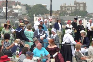 브로드스테어스 디킨스 축제 2013년 사진. 사람들은 축제의 일환으로 다양한 디킨스 시대의 등장인물 복장을 하고 있습니다. 찰스 디킨스가 자주 머물렀던 블리크 하우스(구 포트 하우스)가 배경에 보입니다.