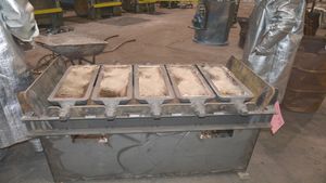 주석병에 걸린 녹인 주석을 잉곳 몰드에 붓는 모습. 록 아일랜드 병기창 합동 제조 및 기술 센터, 일리노이주 록 아일랜드, 2017년.