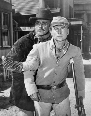 1961년 서부극 시리즈 반역자 에피소드 "Jerkwater"에서 닉 애덤스 뒤에 있는 데너