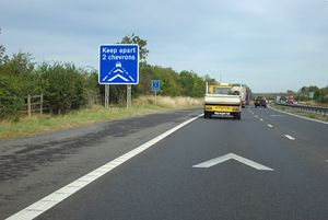 영국 도로에서 역 V자형 차선 표시 두 개 간의 안전 거리를 유지하도록 촉구하는 도로 표지판