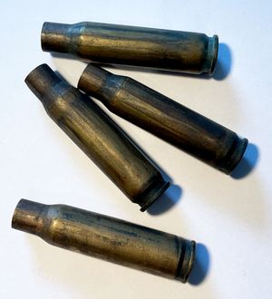 가스 배출 플루트에서 의도적인 추진제 가스 유입으로 인해 앞쪽 바깥 표면에 그을린 자국이 있는 발사된 탄피