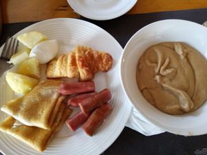 소시지, 크루아상 팬케이크, 감자, 계란과 함께 제공되는 톰 브라운 한 그릇.