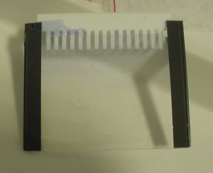 샘플 콤(흰색)을 스페이서(검은색) 사이에서 제거하기 전 중합된 분리 젤과 스태킹 젤. 스태킹 젤에는 소량의 브로모페놀 블루가 포함되어 가시성을 높인다.