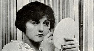 페기 하일랜드가 필름 펀(Film Fun) (1917)에서 가짜 속눈썹을 붙이고 있다