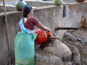 발효된 캐슈 과일 주스를 증류를 위해 냄비로 옮기는 모습.