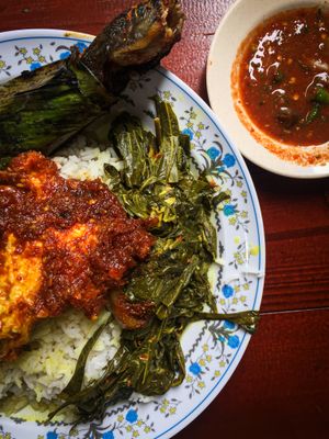 말레이 나시 참푸르의 전형적인 모습 중 하나. 바나나 잎으로 싼 이칸 바카르(구운 메기), 새콤한 소스인 Air Asam과 함께 제공되며, Pucuk Ubi Masak Lemak (코코넛 밀크로 요리한 카사바 잎)과 Sambal Telur (매운 삼발 소스에 넣은 계란)을 곁들인다.