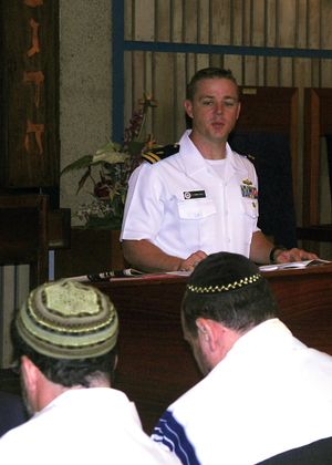 미 해군 군목이 진주만에서 열린 홀로코스트 추모 행사에서 니묄러 목사의 시 "그들이 왔을 때"의 일부를 낭독하고 있다. 2009년 4월 27일.