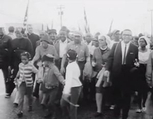 1965년 3월 25일 셀마에서 몽고메리까지 행진 마지막 날, 랄프 데이비드 아버나티와 후아니타 존스 아버나티(Juanita Jones Abernathy)의 아이들이 이끄는 시위대가 몽고메리의 US 80을 따라 걷고 있다.