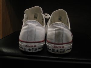 현재 뒤꿈치 로고가 표시된 흰색 로우컷 올스타 스니커즈 한 켤레