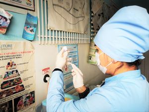 간호사가 USAID가 제공한 COVID 백신 투여량을 준비하고 있다.