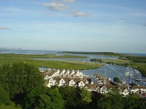 크라이스트처치 항구와 에이번 강과 스토 강이 합류하는 점토 웅덩이(오른쪽 하단). 스탠피트 마쉬(왼쪽 중앙), 윅, 본머스(오른쪽 중앙) 및 헨기스트버리 헤드(오른쪽 상단). 왼쪽 상단의 가느다란 해변 오두막은 머데포드 스핏의 위치를 보여주며, 수평선에는 와이트 섬이 있다.