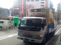 주간 점등을 실시하는 운송 회사의 트럭 (전면 스티커의 절반이 거울 문자로 되어 있다)