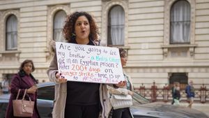 알라 압드 엘-파타의 여동생이 회의 기간 동안 영국 외무·영연방·개발부 밖에서 시위하고 있다.