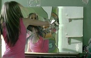 라빈이 분노를 표출하기 위해 손으로 거울을 부수고 있다.