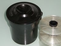 수동 현상에 사용되는 소형 현상 탱크와 릴. 필름을 릴에 감아 탱크에 넣고 각 단계의 약품을 순서대로 부어 처리한다.